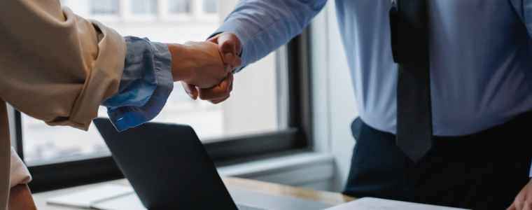 crop colleagues shaking hands in office